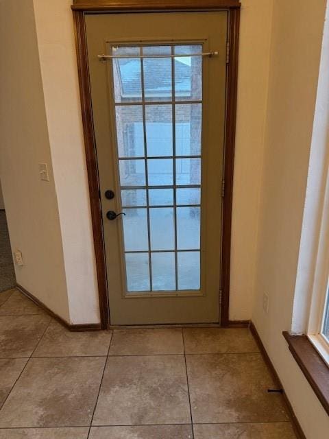 doorway with light tile patterned floors and a wealth of natural light