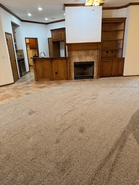 unfurnished living room with light colored carpet, ceiling fan, and ornamental molding