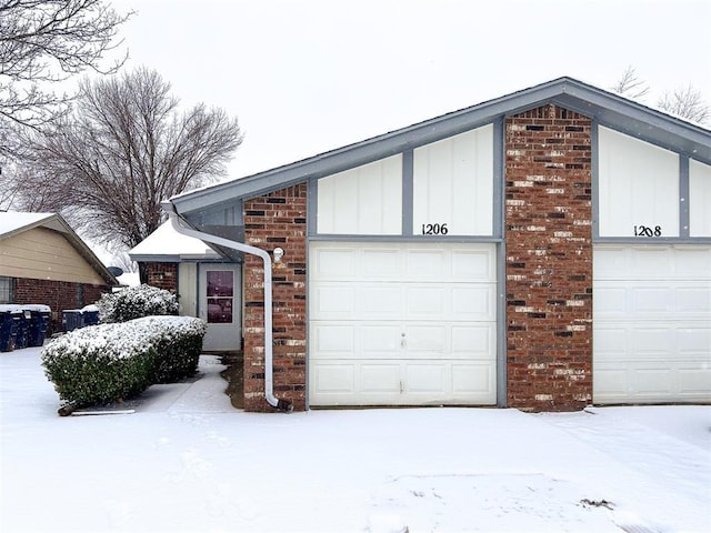 snow covered property featuring a garage