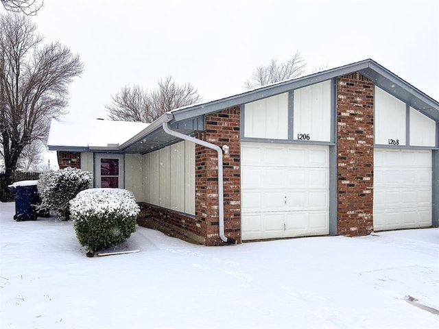 view of snowy exterior with a garage