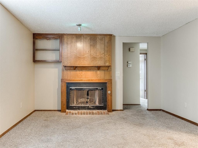 unfurnished living room with carpet floors, a textured ceiling, and a fireplace