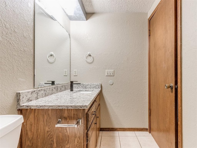 bathroom featuring a textured ceiling, tile patterned floors, vanity, and toilet