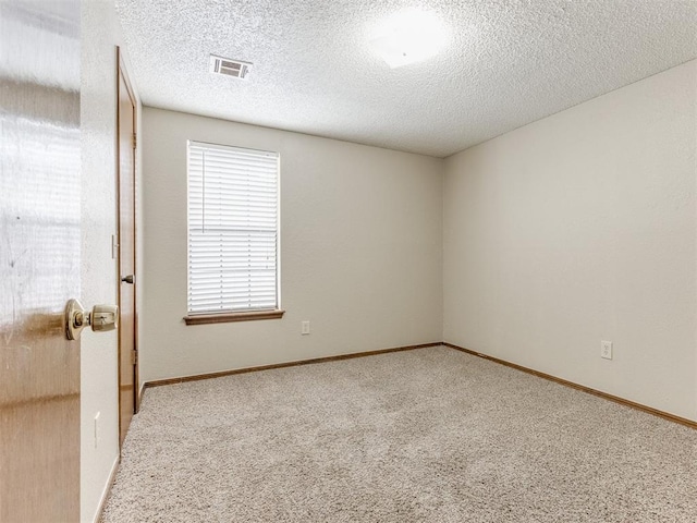 empty room with carpet floors and a textured ceiling