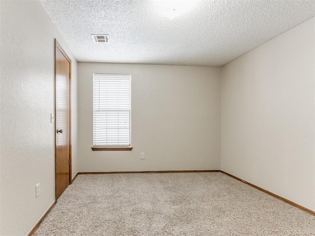 unfurnished room featuring a textured ceiling and carpet floors