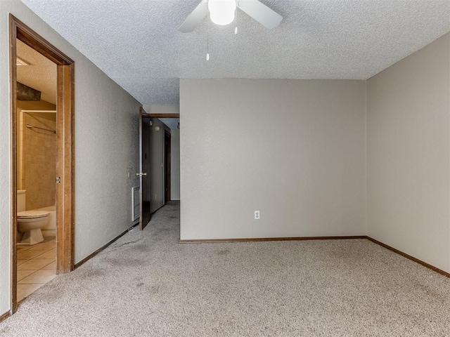 unfurnished room with ceiling fan, light colored carpet, and a textured ceiling