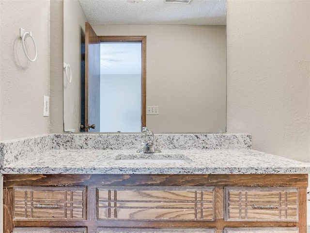 bathroom featuring vanity and a textured ceiling