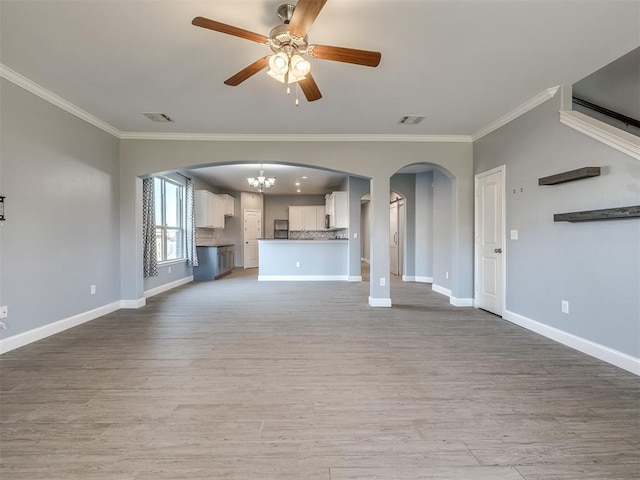 unfurnished living room with ceiling fan with notable chandelier, crown molding, and light hardwood / wood-style flooring