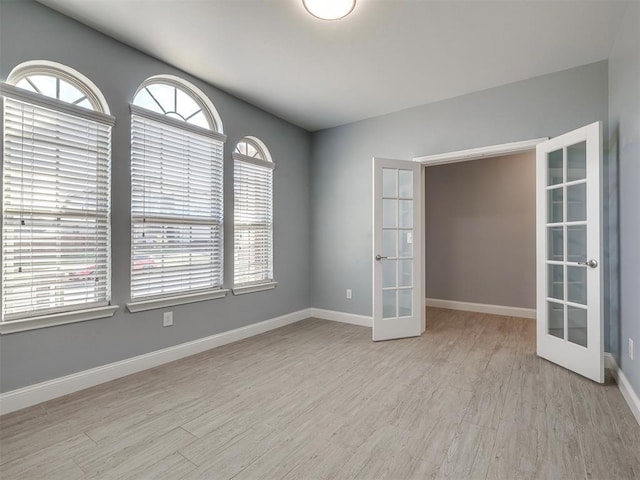 unfurnished room featuring light hardwood / wood-style flooring and french doors