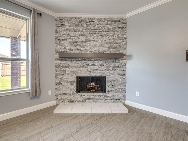 unfurnished living room with a stone fireplace, plenty of natural light, and crown molding