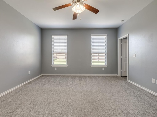 carpeted spare room with ceiling fan