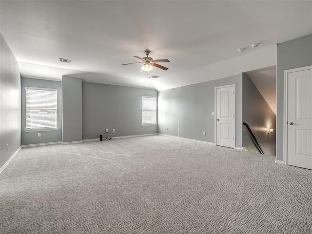 carpeted spare room featuring vaulted ceiling and ceiling fan