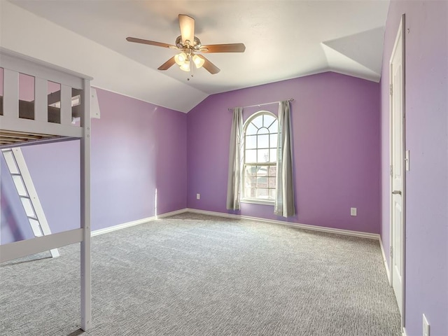 interior space with carpet flooring, ceiling fan, and lofted ceiling