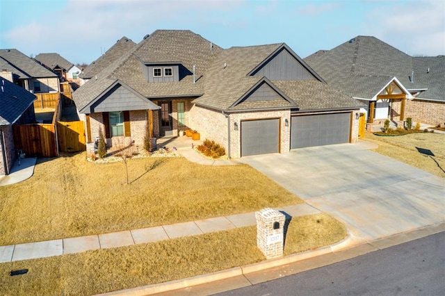 view of front of house with brick siding, driveway, a garage, and fence