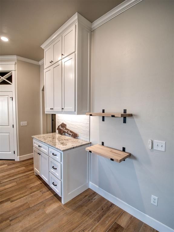 washroom with recessed lighting, wood finished floors, baseboards, and ornamental molding