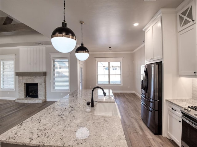 kitchen with a sink, white cabinets, ornamental molding, and stainless steel appliances