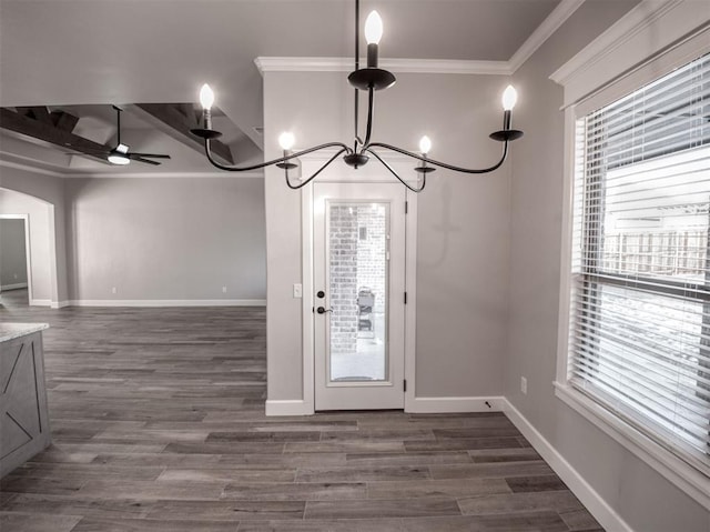 unfurnished dining area with arched walkways, baseboards, and dark wood-style flooring