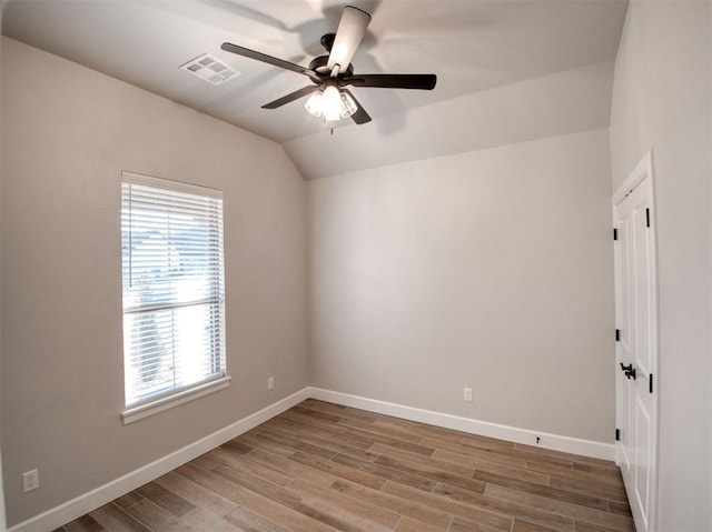 unfurnished room with visible vents, baseboards, lofted ceiling, and light wood finished floors