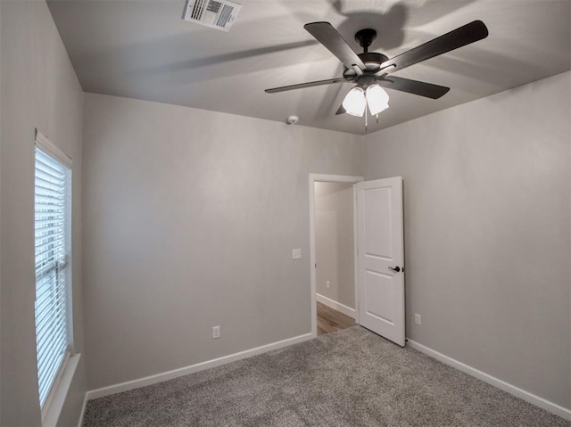 spare room with visible vents, baseboards, and carpet