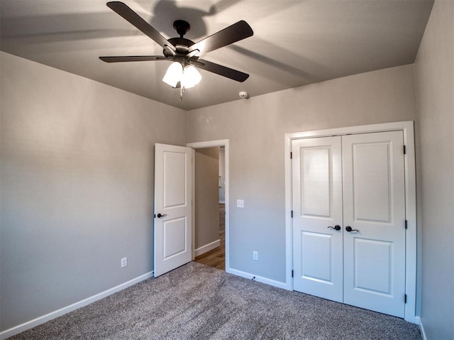 unfurnished bedroom with carpet flooring, baseboards, a closet, and ceiling fan