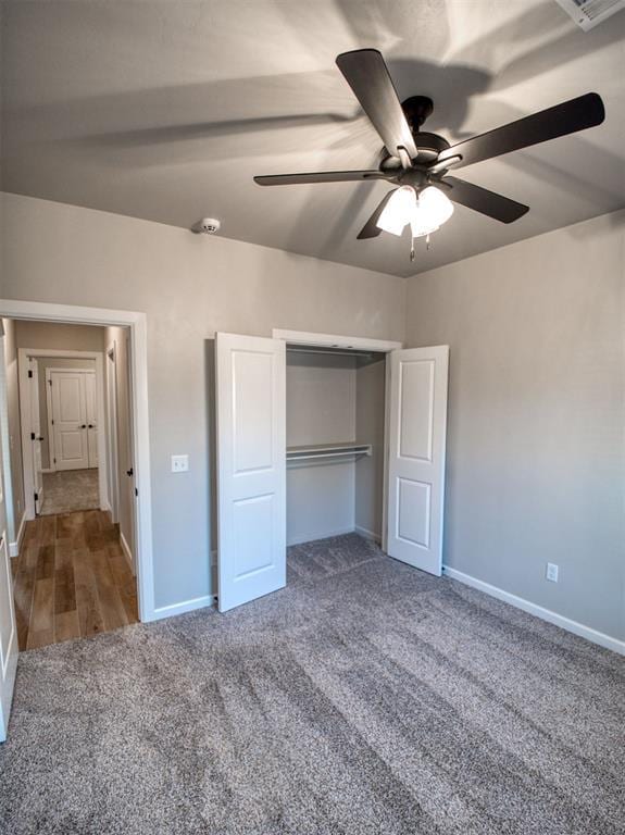 unfurnished bedroom featuring a closet, a ceiling fan, baseboards, and carpet floors