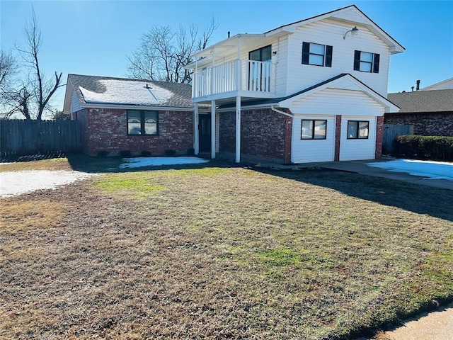 front of property with a balcony, a front lawn, and a patio area