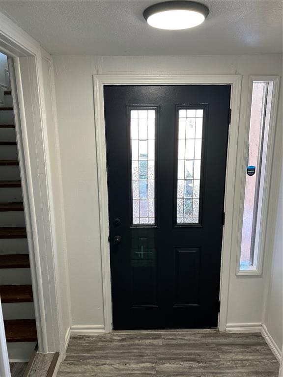 foyer entrance with hardwood / wood-style floors and a textured ceiling