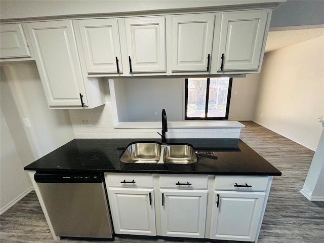 kitchen featuring dishwasher, white cabinetry, sink, and dark stone counters