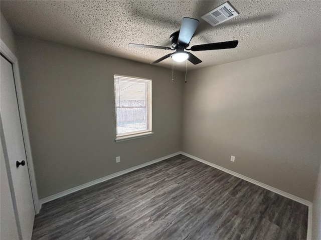 spare room featuring ceiling fan, dark hardwood / wood-style flooring, and a textured ceiling