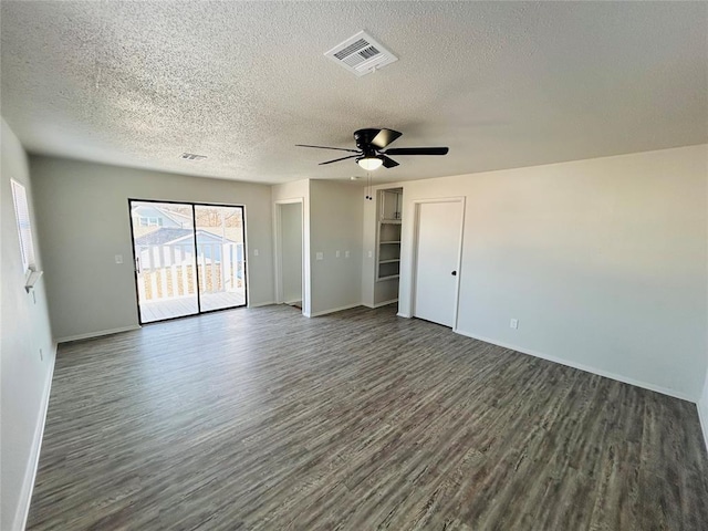 empty room with a textured ceiling, ceiling fan, and dark hardwood / wood-style floors