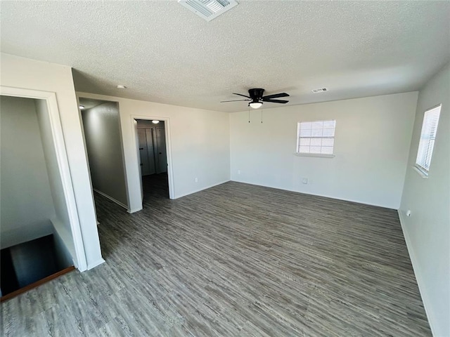 spare room with dark hardwood / wood-style flooring, a textured ceiling, and ceiling fan