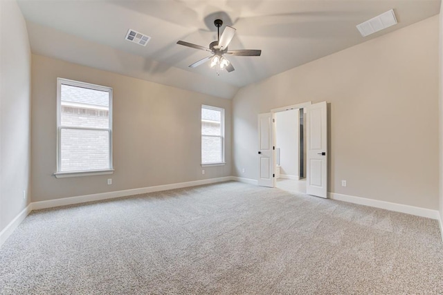 spare room featuring ceiling fan, lofted ceiling, light carpet, and a wealth of natural light