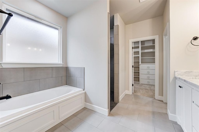 bathroom featuring tile patterned flooring, vanity, and a bathing tub