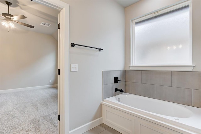 bathroom with a wealth of natural light, a washtub, ceiling fan, and lofted ceiling