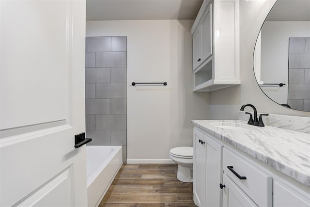 full bathroom featuring vanity, hardwood / wood-style flooring, toilet, and tiled shower / bath combo