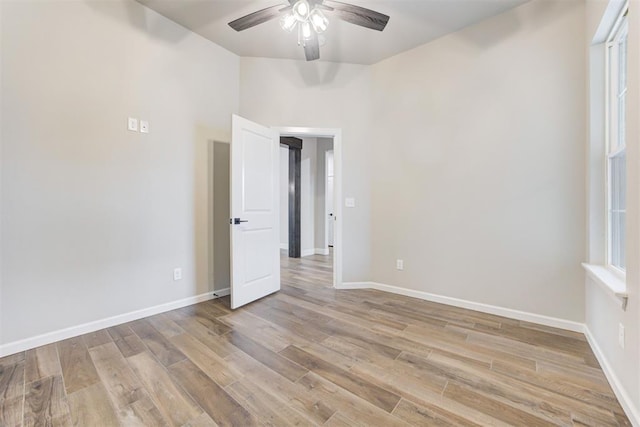 empty room with ceiling fan and light wood-type flooring