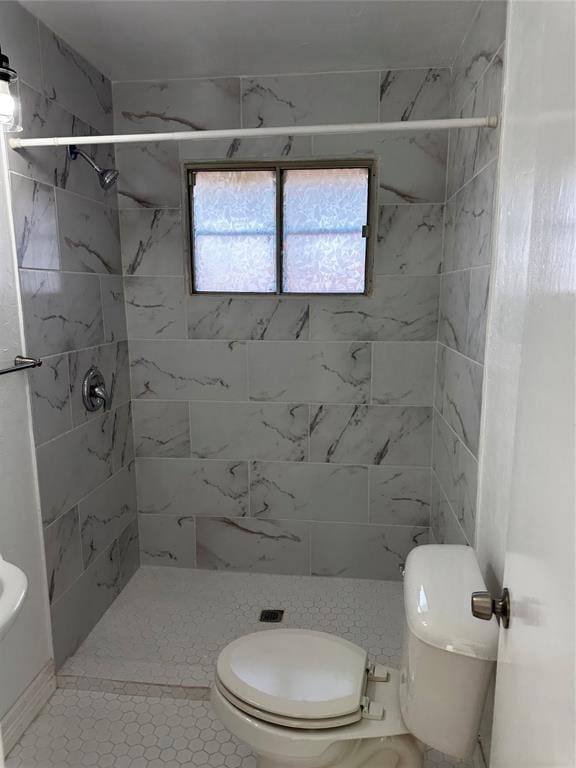 bathroom with toilet and a tile shower