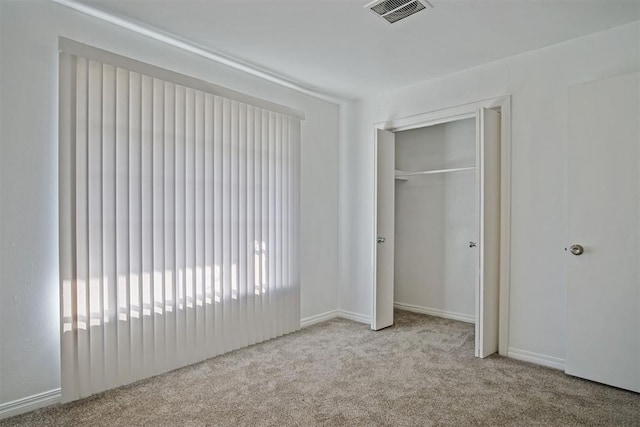 unfurnished bedroom with a closet, visible vents, and carpet floors