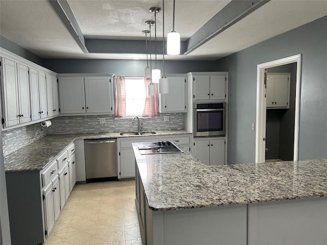 kitchen with appliances with stainless steel finishes, decorative light fixtures, white cabinetry, and sink