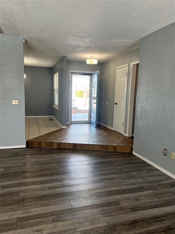 entrance foyer featuring a textured ceiling and dark hardwood / wood-style floors