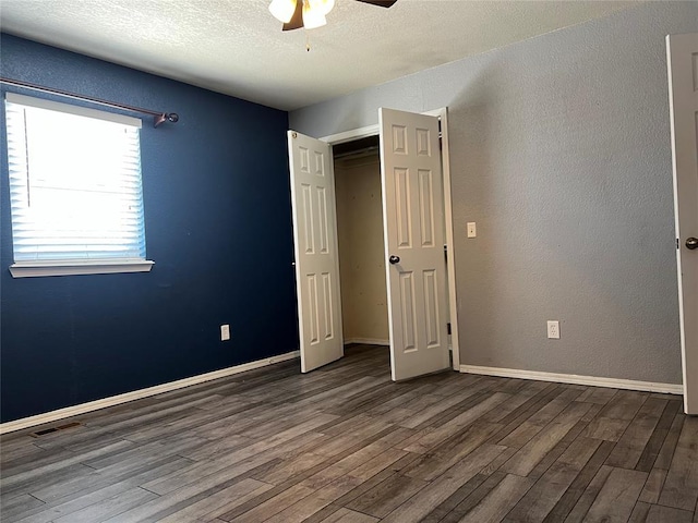 unfurnished bedroom with ceiling fan, a closet, wood-type flooring, and a textured ceiling