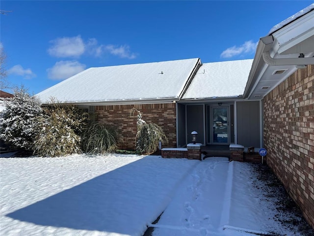 view of snow covered back of property