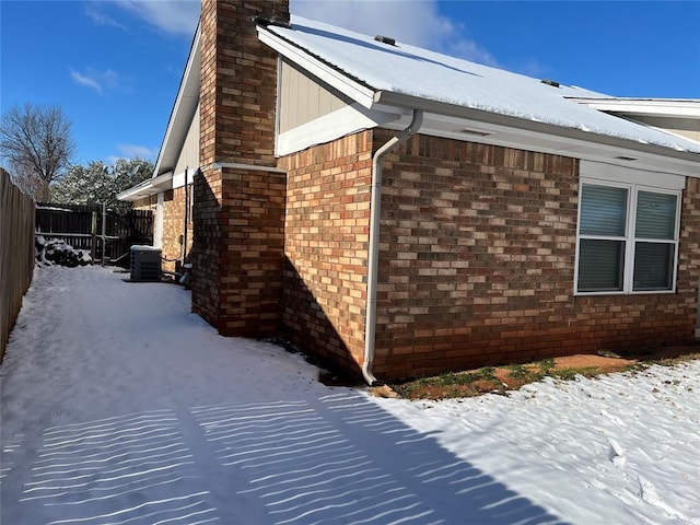 view of snowy exterior with central AC