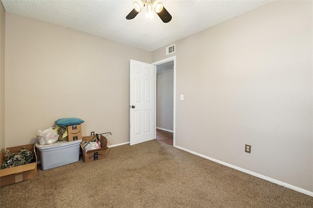 carpeted spare room with ceiling fan and a textured ceiling