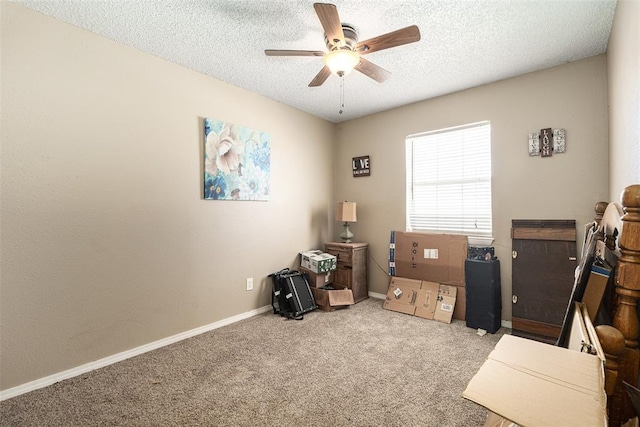 misc room with a textured ceiling, light colored carpet, and ceiling fan