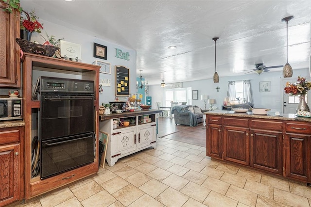 kitchen with double oven, ceiling fan, light tile patterned flooring, and decorative light fixtures