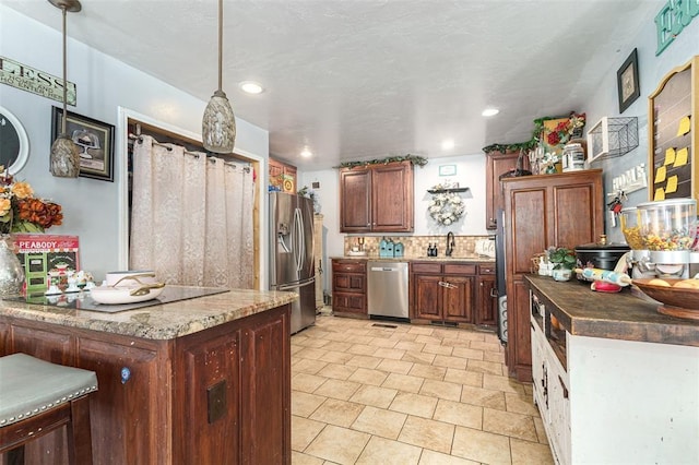 kitchen featuring backsplash, sink, hanging light fixtures, and appliances with stainless steel finishes