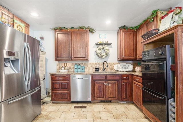 kitchen featuring sink, light stone countertops, light tile patterned floors, tasteful backsplash, and stainless steel appliances