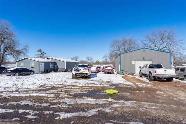 snow covered parking featuring a garage