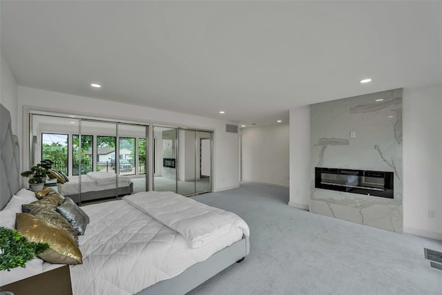 bedroom featuring carpet flooring, multiple closets, and a fireplace