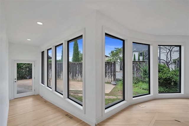 doorway to outside with light wood-type flooring and a wealth of natural light